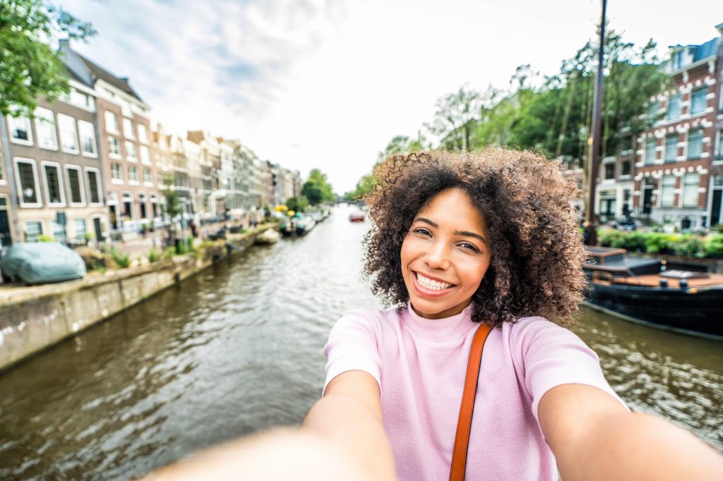 Happy female tourist visiting Amsterdam city, Netherlands