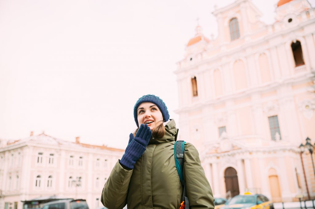 Vilnius, Lithuania. Young Beautiful Pretty Caucasian Girl Woman Tourist Smiling On Background Church